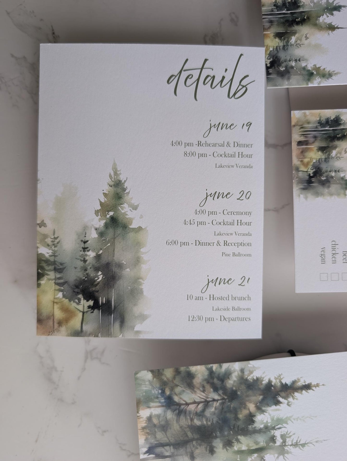 Invitation card with watercolor trees and event details on a marble surface