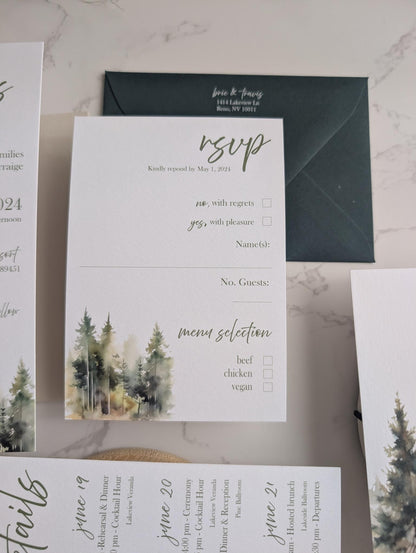 Wedding invitation set with envelope, RSVP card, and menu on a marble surface.