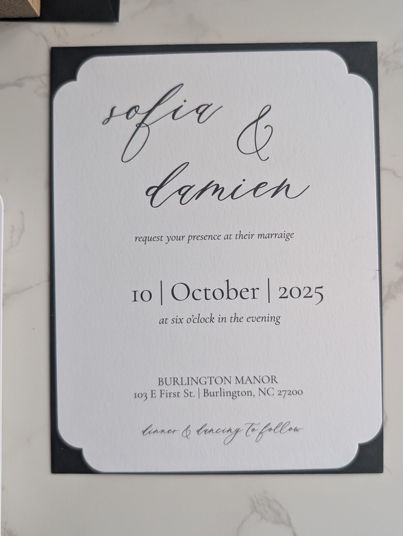 Wedding invitation card with 'sofia & damien' and event details on a marble surface.