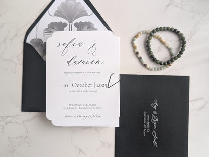 Wedding invitation card with envelope and bracelet on a marble surface