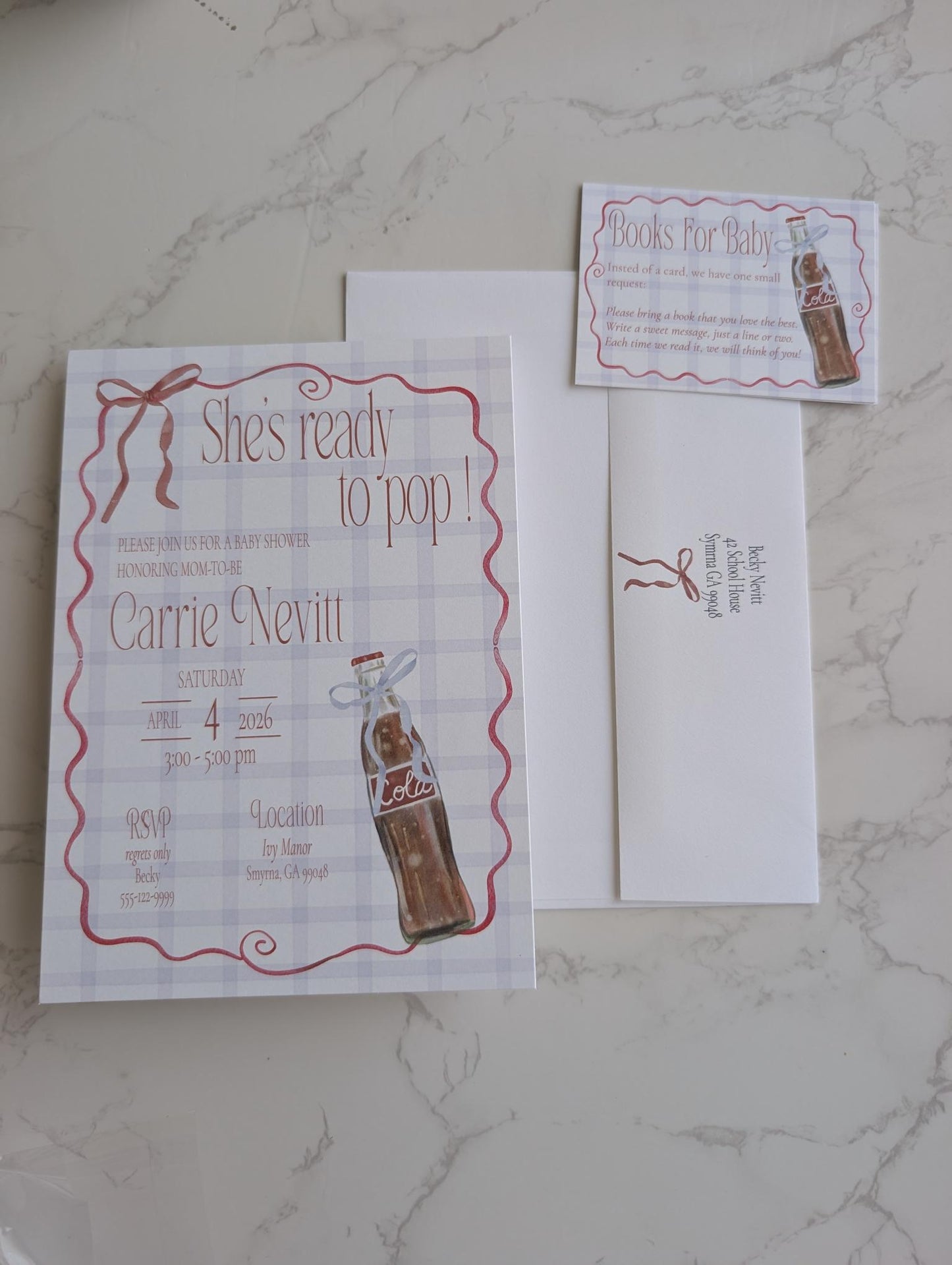 A flat-lay of a personalized birthday invitation suite featuring a main invitation card, an RSVP card, and an envelope on a light gray marble background. The design has a white and light gray plaid pattern with a red wavy border, brown ribbon graphic, and an illustration of a vintage Coca-Cola bottle.