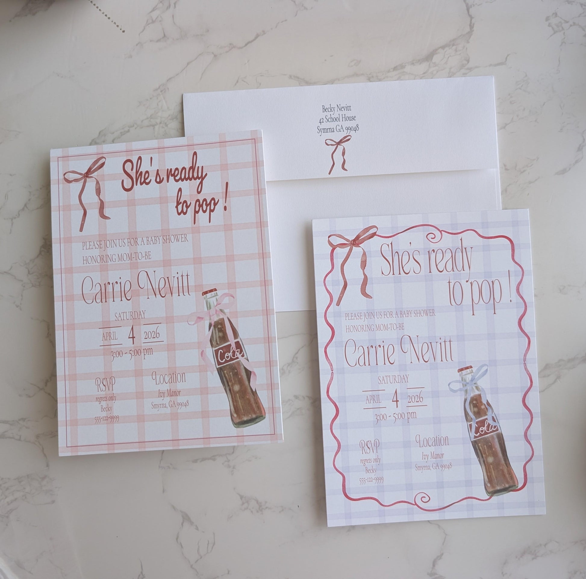 A flat-lay of a matching bridal shower invitation suite featuring a pink and white gingham check pattern, red script text, and an illustration of a vintage Coca-Cola bottle, shown with an envelope on a light marble surface.