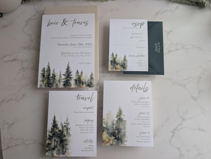 Wedding invitation set with forest design on a marble surface