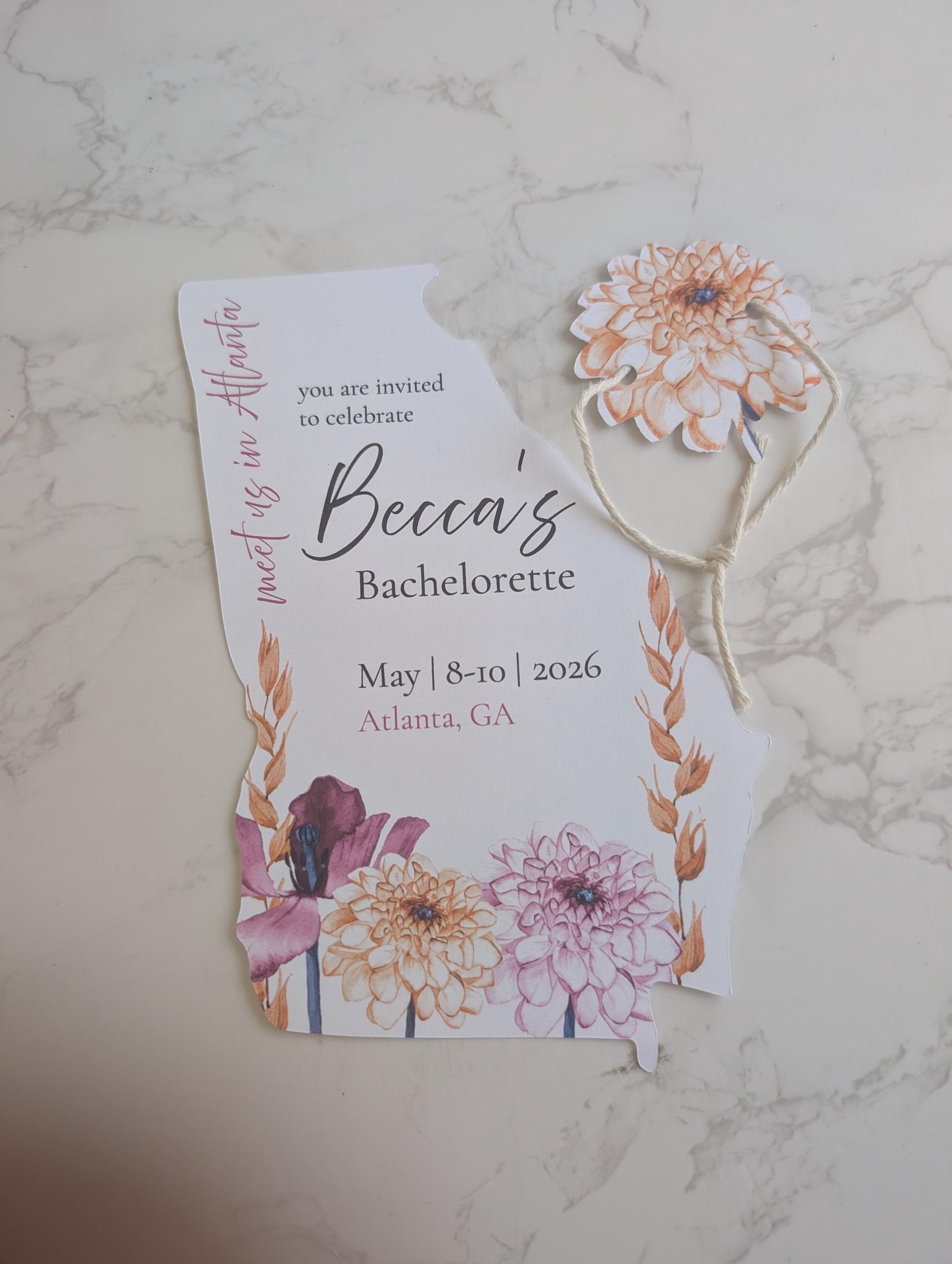 Bachelorette party invitation with floral design on a marble surface