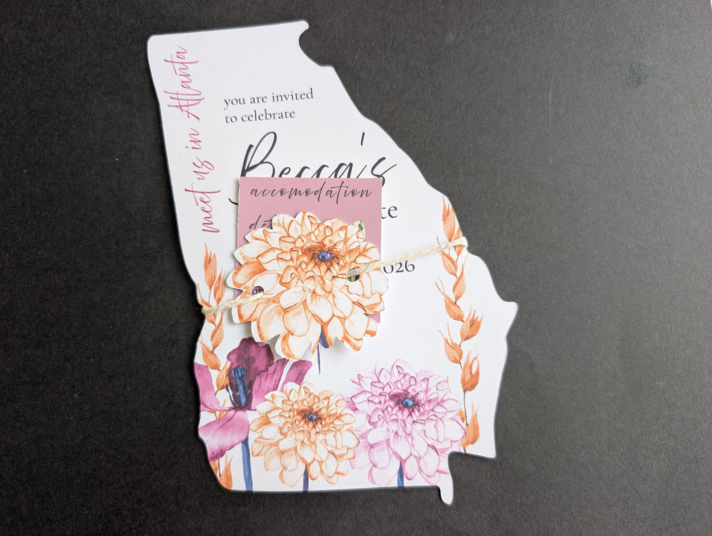 Invitation card shaped like a state with floral design on a black background
