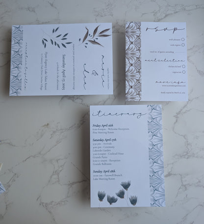 Set of wedding invitations with floral design on a marble surface