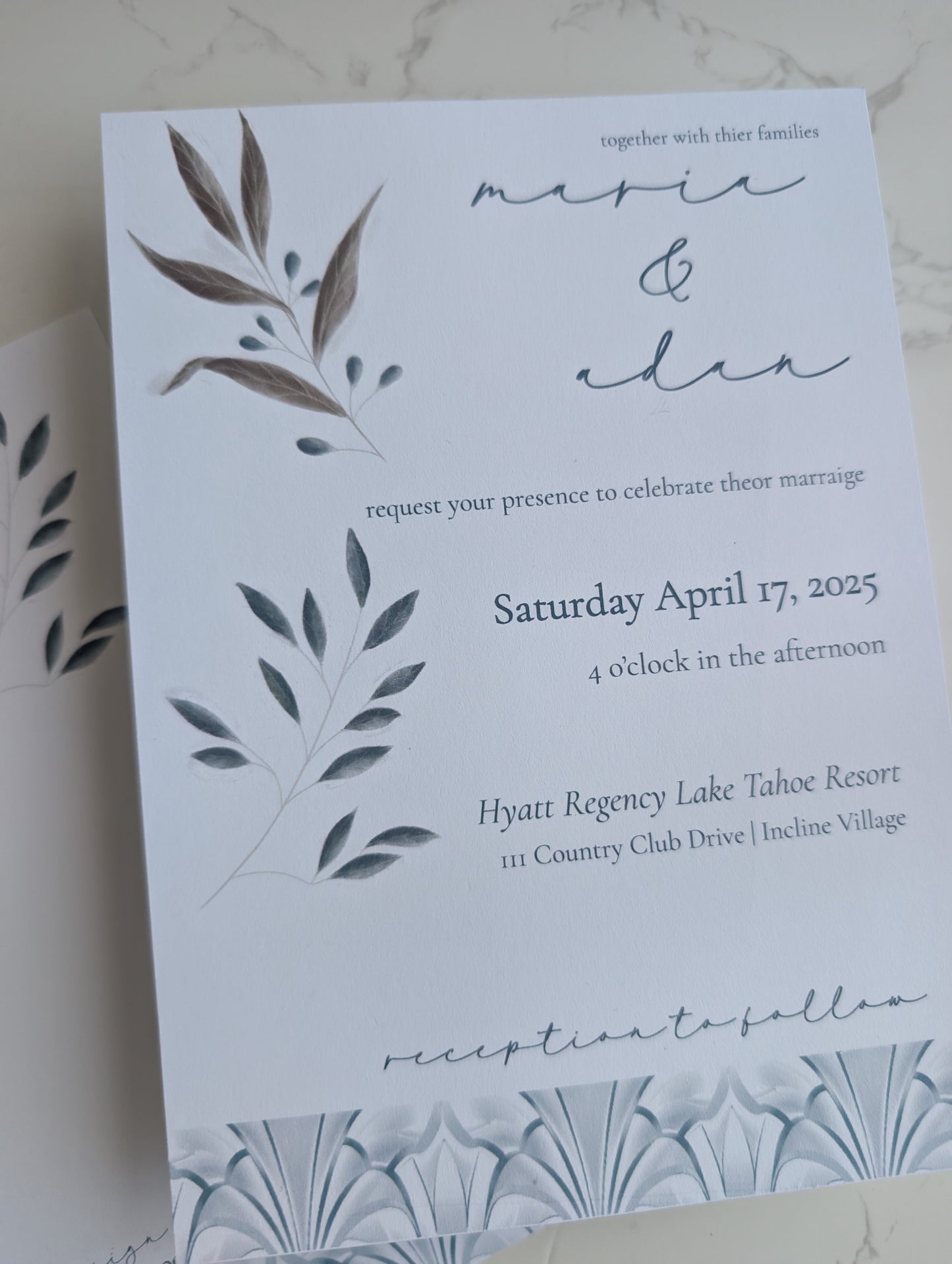 Wedding invitation card with leaf designs on a white background