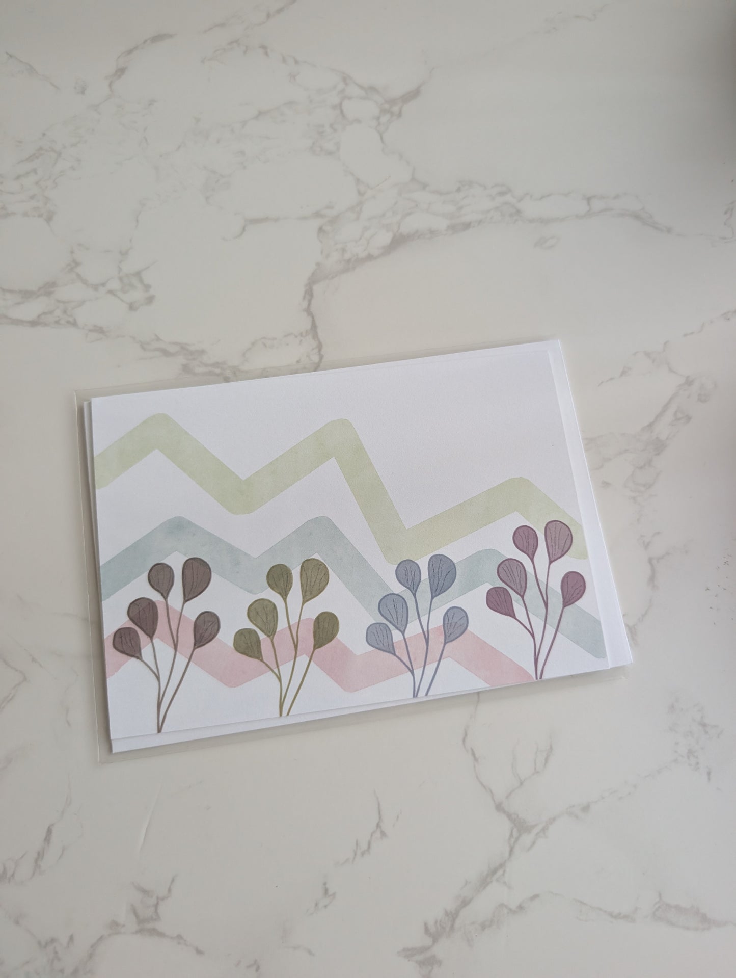 Card with floral design and zigzag pattern on a marble surface
