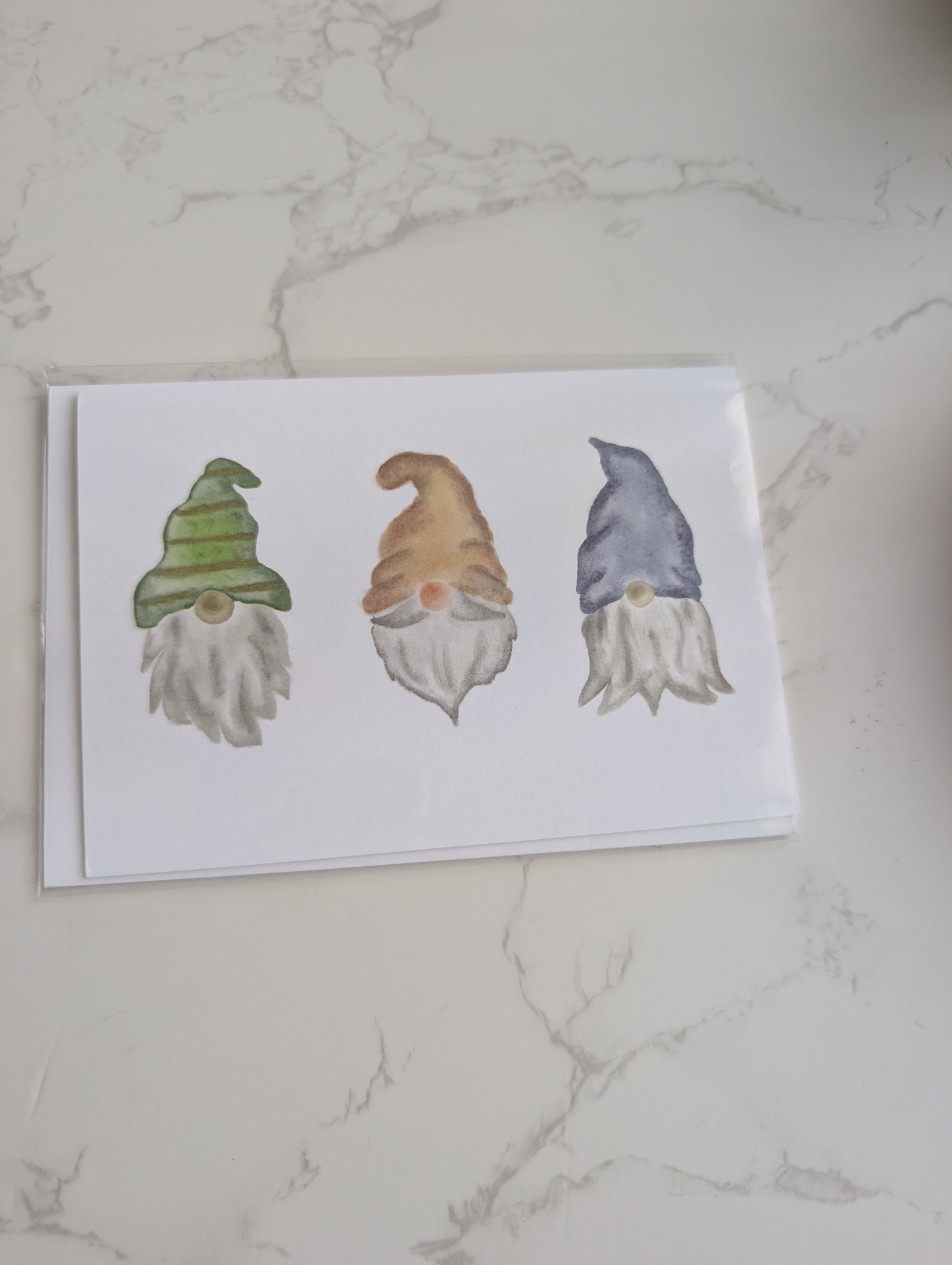 Three cartoon gnomes on a white card with a marble background