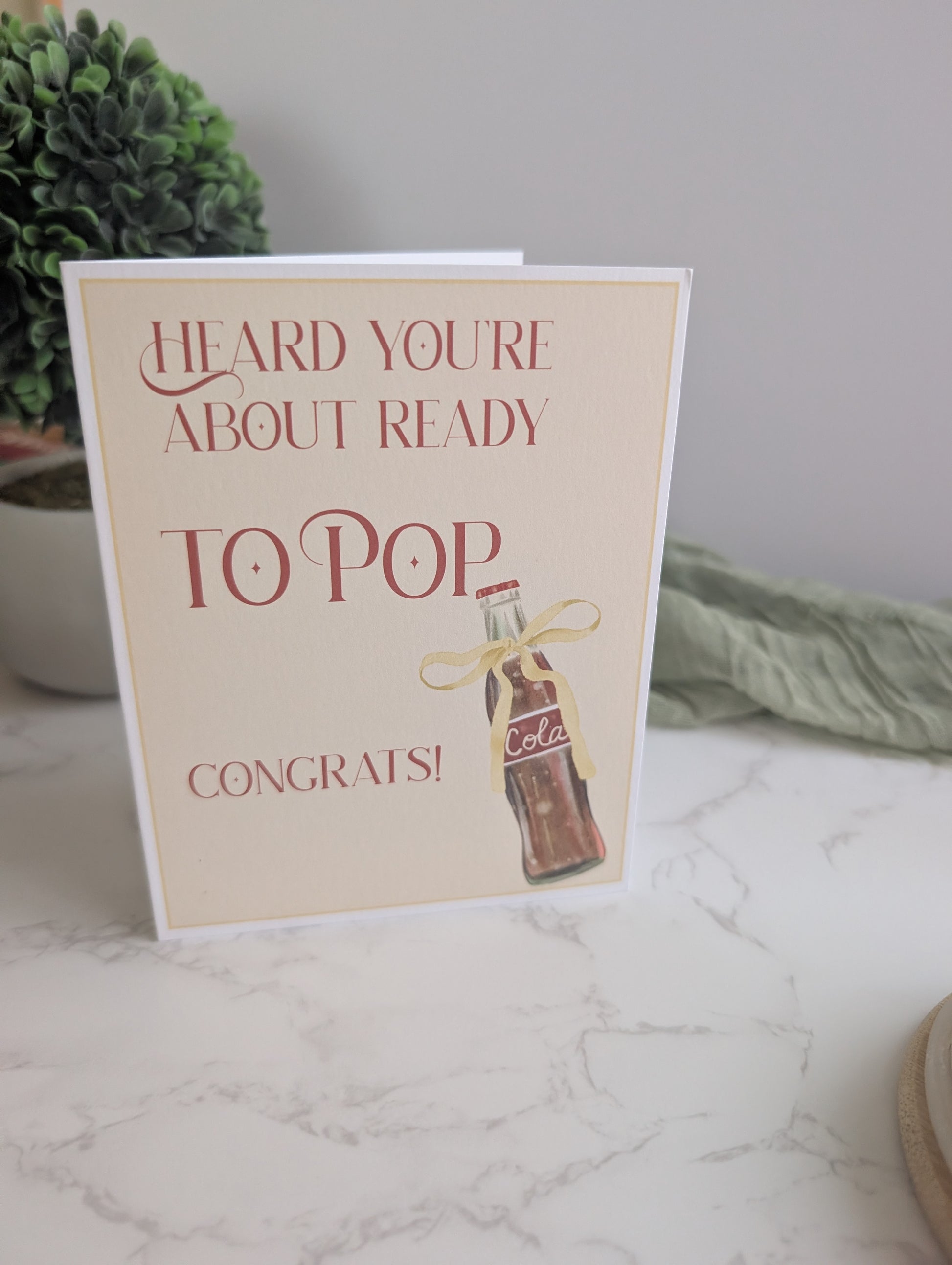 Greeting card with a Coca-Cola bottle illustration on a marble surface