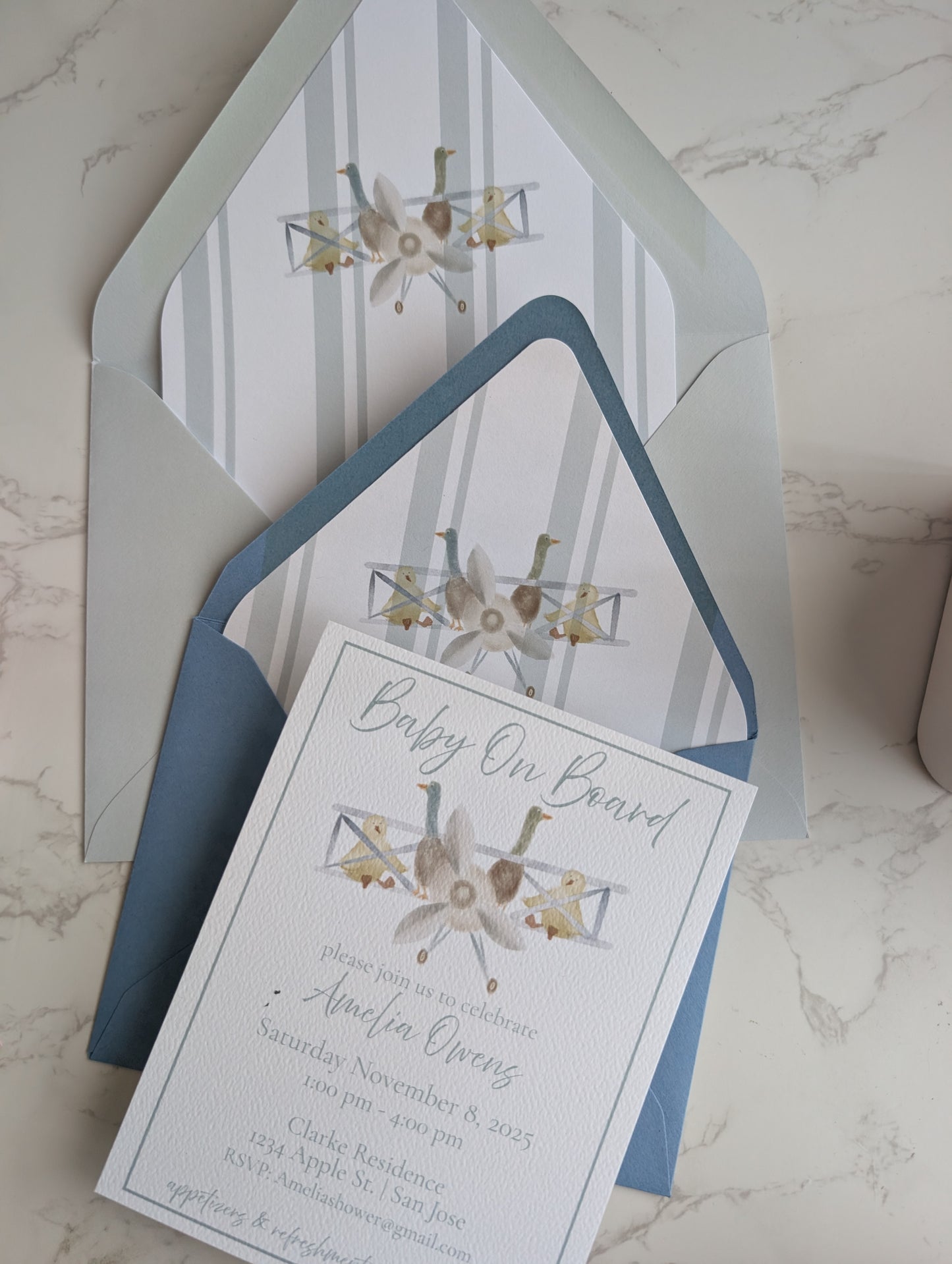 Baby shower invitation with decorative elements on a marble surface