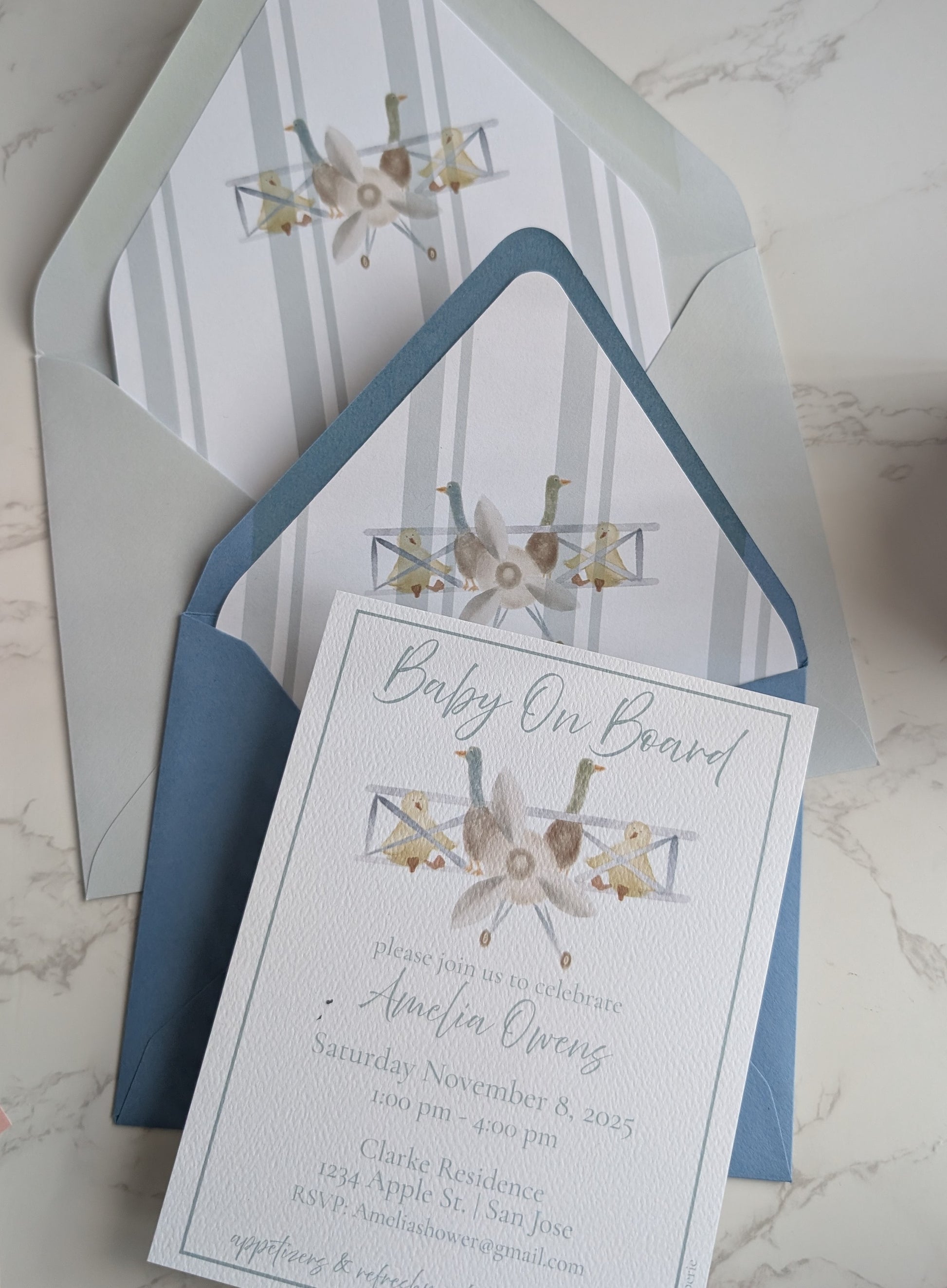 Baby shower invitation with envelope on a marble surface