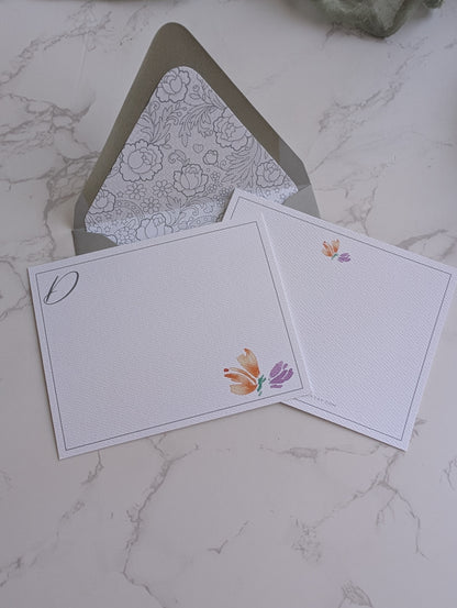 Two greeting cards with floral designs on a marble surface