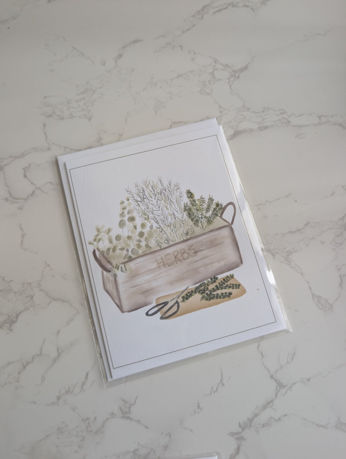 Greeting card with a wooden crate and plants design on a marble surface
