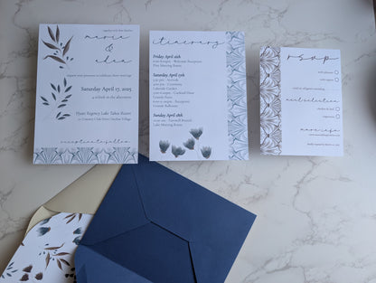 Wedding invitation set with RSVP card, envelope, and details on a marble surface